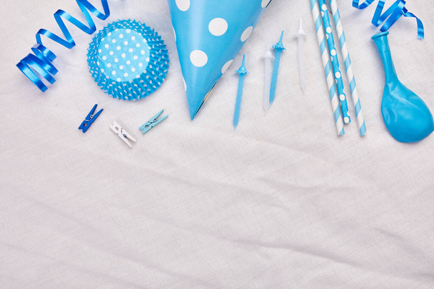 Geburtstagskind flach gelegt, Draufsicht und Kopierraum für Text, Rahmen oder Hintergrund mit blauen Festartikeln, Partyhüten und Luftschlangen, Geburtstags- oder Partygrusskarte. - Foto, Bild