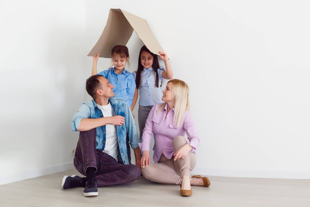 koncepcja mieszkająca młodą rodzinę. Matka ojciec i dziecko w nowym domu z dachem - Zdjęcie, obraz