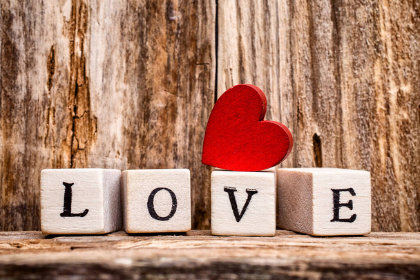 Written on wooden blocks love and red heart. - Valokuva, kuva