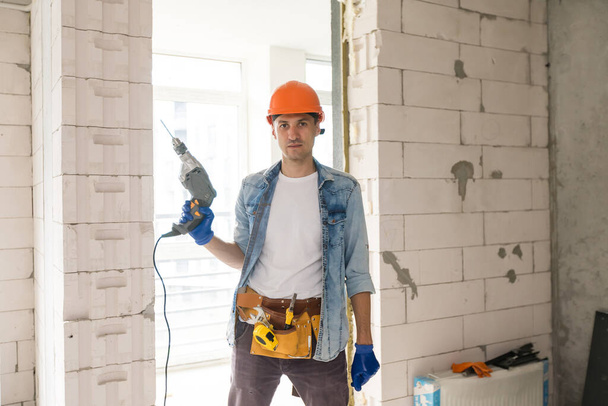 Handyman with a tool belt. House renovation service. - Photo, Image