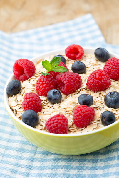 Oatmeal porridge with berries. Raspberries and blueberries. - Foto, imagen