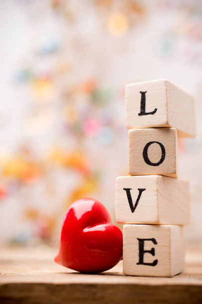 Written on wooden blocks love and red heart. - Фото, изображение
