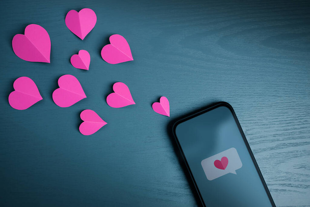 Aşk Mesajı. Sevgililer Günü Konsepti. Cep telefonuyla birine Kalp Sembolü yollamak. Üst Görünüm - Fotoğraf, Görsel