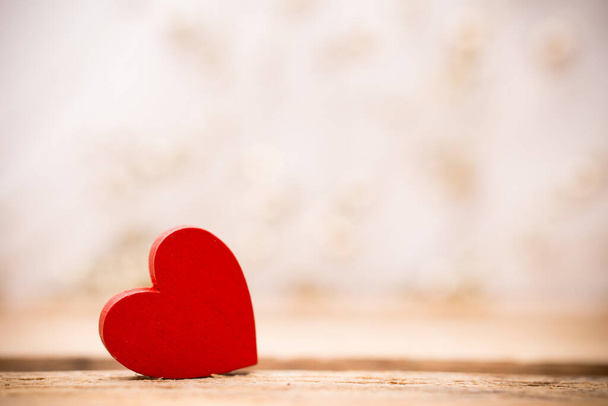 Red wooden heart on a wooden background with boke background. - 写真・画像