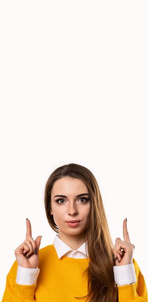 A tua promoção aqui. Retrato de menina atraente apontando os dedos para cima, mostrando bom site de compras, recomendo clique no link, upload app or subscribe. Estúdio filmado, fundo branco. Mock up espaço de cópia - Foto, Imagem