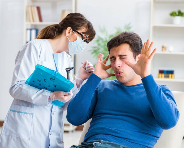 Lekarz sprawdzający uszy pacjentów podczas badania lekarskiego - Zdjęcie, obraz