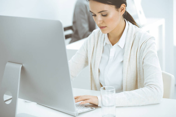 Casual dressed business woman working with computer in office. Lawyer or accountant at work - Foto, Bild