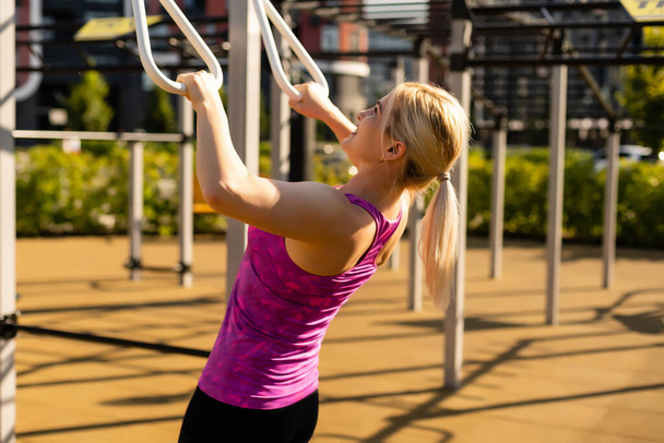 woman working out in gym on equipment outdoors having fun - Foto, Bild