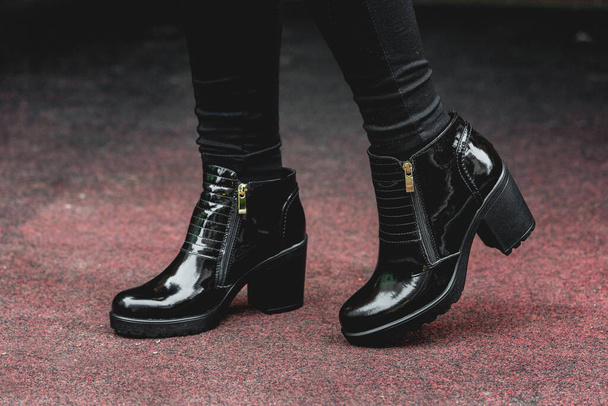 Schwarze Lacklederstiefel für Frauen. Straßenfoto. Mode Werbung Schuhe Fotos. - Foto, Bild