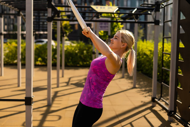 Fitness-Sportlerin in modischer Sportbekleidung, die Yoga-Fitness-Übungen auf der Straße macht, Outdoor-Sport, urbaner Stil - Foto, Bild