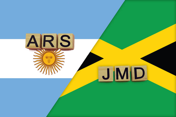 Argentina and Jamaica currencies codes on national flags background. International money transfer concept - Photo, Image