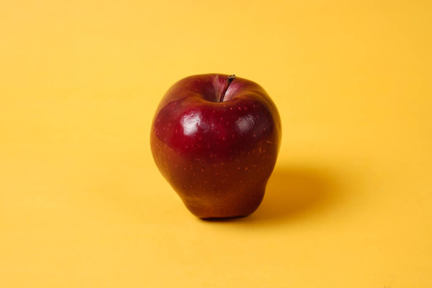 Fényes, friss almák. Oldalnézetből. A friss alma elhelyezésének koncepcióját sárga háttérrel kombinálják, amelyet gyakran használnak tervezési sablonokhoz és mockupokhoz. Egy alma gyönyörű alakja.. - Fotó, kép