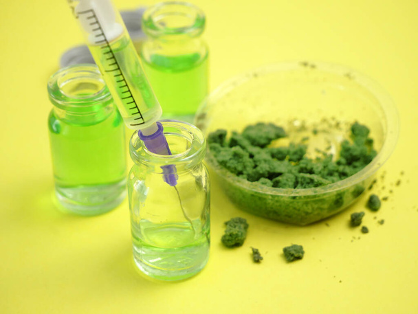 Kannabisöljyä marihuana kasvi pulloissa kasvi sinisellä pohjalla. Kannabis kosmetiikka käsite - Valokuva, kuva