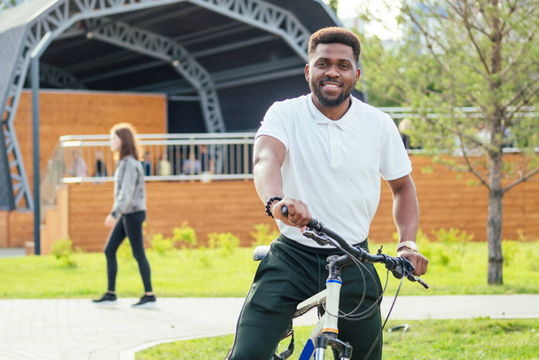 Umwelt- und Verkehrskonzept. moderner junger afroamerikanischer Geschäftsmann radelt mit dem Fahrrad zur Arbeit - Foto, Bild