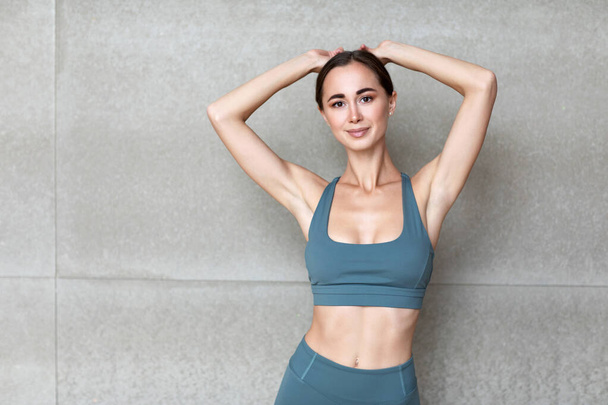 Healthy and Fitness concept - portrait woman posing in sportswear on gray wall in studio. - Fotoğraf, Görsel