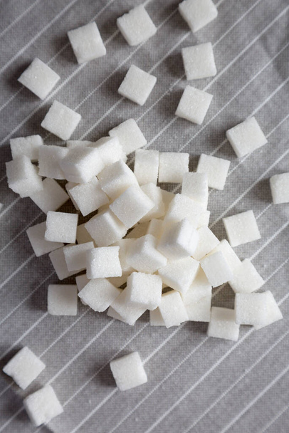 Органические белые кубики сахара на ткани, вид сверху. Плоская кладка, вид сверху, навес. - Фото, изображение