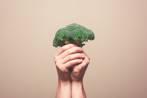 Mains tenant du brocoli
 - Photo, image