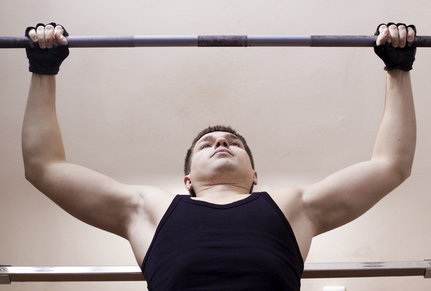 Man lifting metal weight - 写真・画像
