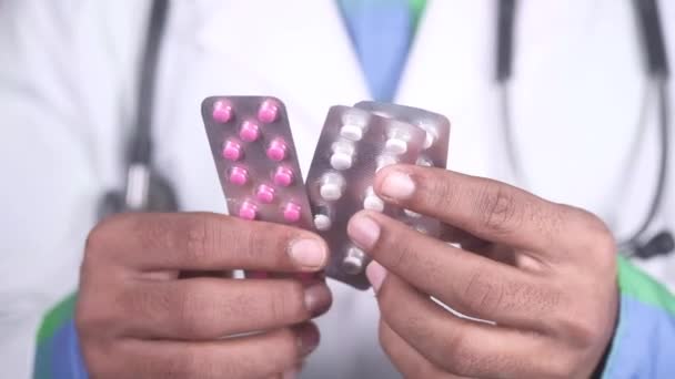 γιατρός σε λευκό παλτό κρατώντας χάπια της συσκευασίας κυψέλης  - Πλάνα, βίντεο