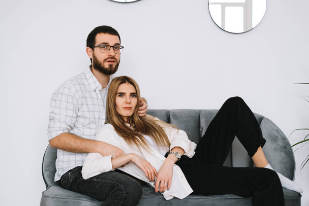 Young happy couple embrace and resting on a sofa at home. High quality photo - Foto, immagini