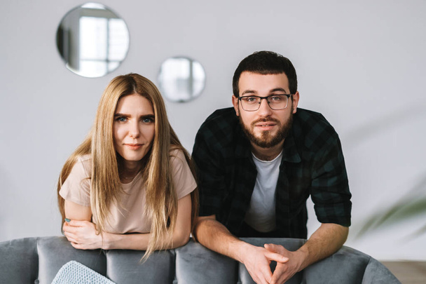 Portrait of cheerful couple staying near sofa at home. High quality photo - Fotó, kép