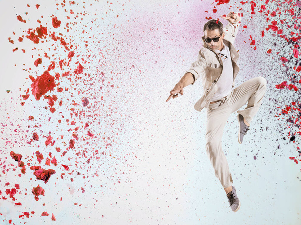 Handsome, flexible dancer jumping into the paint splash - Foto, imagen