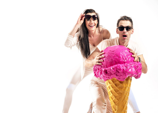 Summer style shot of an attrcative couple holfing huge ice cream scoop - Zdjęcie, obraz