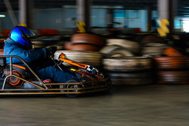 Dynamischer Kart-Wettbewerb im Tempo mit verschwommener Bewegung auf einer ausgestatteten Rennbahn 2019 - Foto, Bild