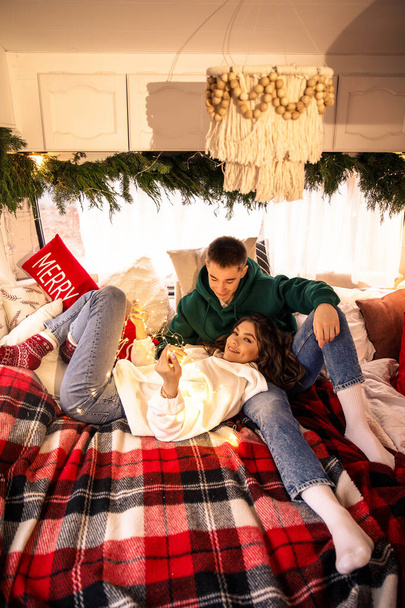 young beautiful couple having fun and relaxing in bed with christmas decorations - Foto, afbeelding
