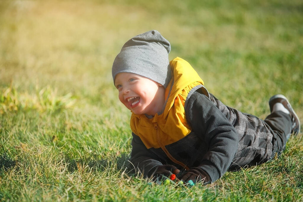 Retrato emocional de um menino caucasiano em um parque de outono em um passeio.  - Foto, Imagem