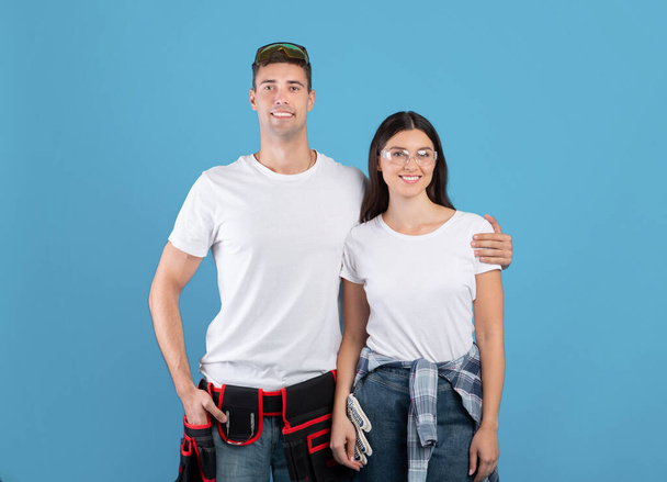 Concetto di riparazione. Ritratto di giovane coppia con occhiali di sicurezza e cintura da costruzione - Foto, immagini