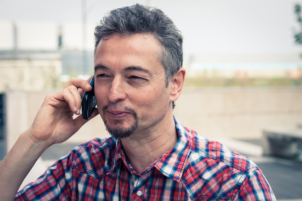 Man in short sleeve shirt talking on phone - Foto, Bild
