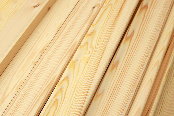 As ripas de madeira estreitas ou as tábuas no close-up estão em uma pilha. Esta é uma nobre madeira polida na carpintaria.  - Foto, Imagem