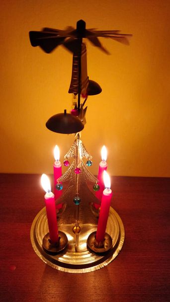 Bougeoir de Noël traditionnel tchèque avec quatre bougies allumées. L'air chaud des bougies fait tourner les cloches pour qu'elles clignent pour produire une atmosphère authentique et belle. - Photo, image