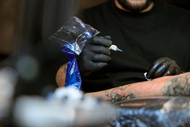 professionnel mâle barbu caucasien tatouage maître travaille dans confortable atmosphère studio - Photo, image