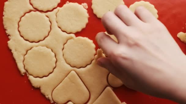Női kéz veszi cookie-k formájában szív és kerek Szent Valentin-nap piros műanyag penész a piros szilikon sütő szőnyeg.  - Felvétel, videó