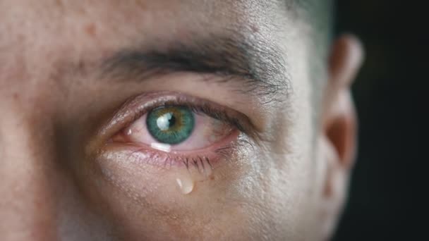 Een close-up van een huilende man met tranen in het oog. Depressieve man in wanhoop huilt verdriet. Tranen op zijn gezicht. - Video