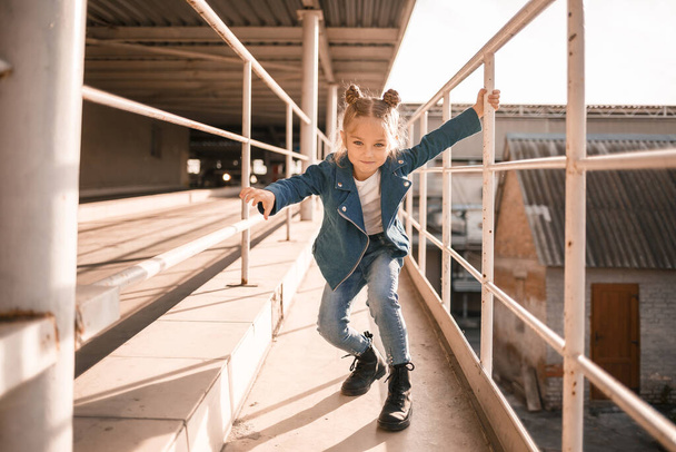 Κορίτσι με τζιν ρούχα χορεύει χιπ-χοπ στο πάρκινγκ. - Φωτογραφία, εικόνα