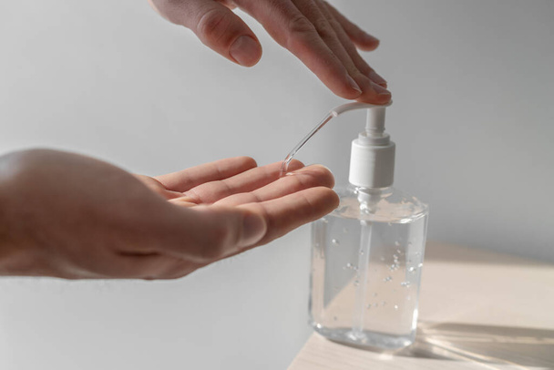 Coronavirus hand sanitizer sanitiser gel for clean hands hygiene corona virus spread prevention. Man using alcohol rub alternative to washing hands - Фото, изображение