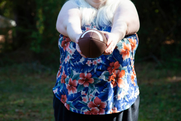 Mujer sosteniendo un balón de fútbol, preparándose para patear - Foto, imagen