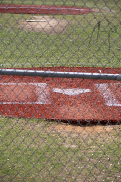 Домашня пластина порожнього бейсбольного поля через паркан
 - Фото, зображення