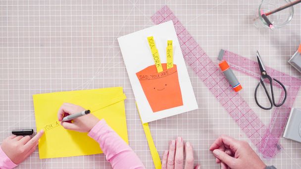 Flat lay. Little girl making a handmade Father's Day card from construction paper. - Fotoğraf, Görsel