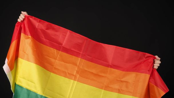 Bandeira LGBTQ ou lésbica gay bi sexual transexual queer ou orgulho homossexual bandeira do arco-íris no fundo preto. Representar símbolo de mão de liberdade, paz, igualdade e amor. Conceito LGBTQ - Foto, Imagem