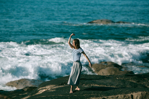 A girl is engaged in dances on the ocean coast. - Fotografie, Obrázek