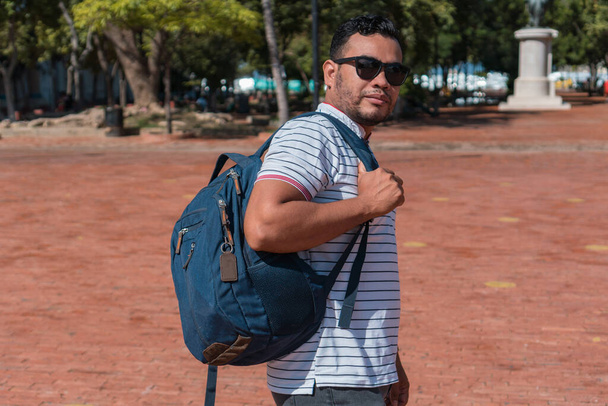 A young man with a backpack walking in the park - Foto, Imagem