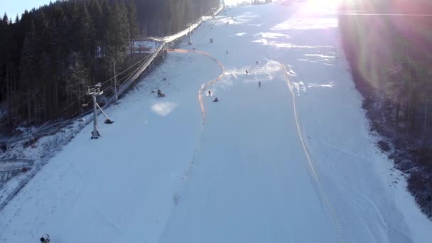 Aerial Drone Widok na wyciągi krzesełkowe dla narciarzy i snowboardzistów w słoneczny dzień w Karpatach, Ukraina, Bukovel - Materiał filmowy, wideo