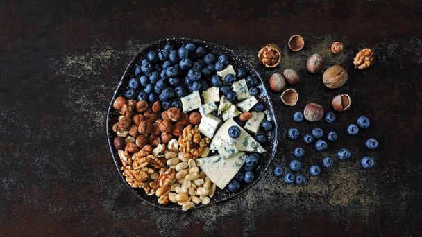 Plate with blue cheese, blueberries and nuts. Keto diet. Keto snack. - Photo, image