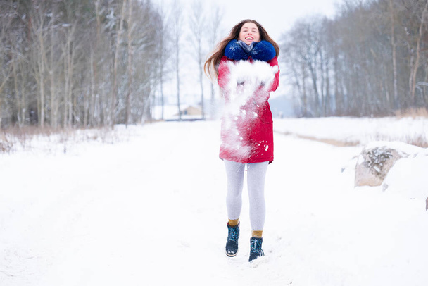 Young woman in red coat enjoy snowy winter  - 写真・画像