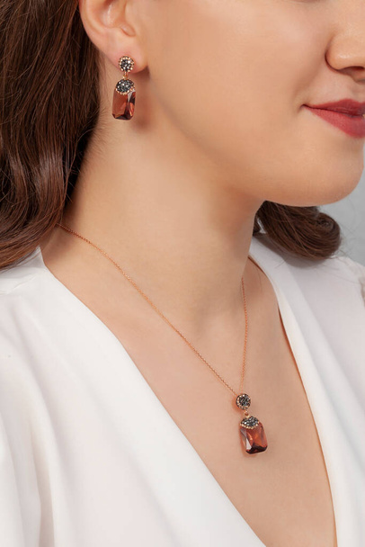 Naturalna kamienna biżuteria na zadbanej dziewczynie z czerwoną szminką. kolczyki, naszyjnik, komplet biżuterii. - Zdjęcie, obraz