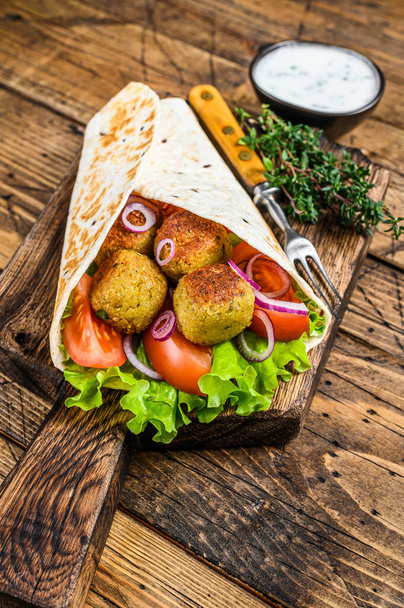 Vegetarische Tortilla wrap met falafel en verse salade, veganistische taco 's. houten achtergrond. Bovenaanzicht. - Foto, afbeelding